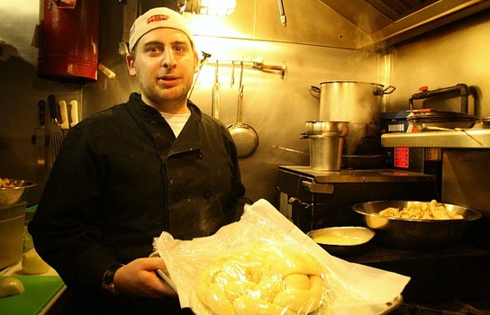 Joshua Levi, the executive chef of Mara's Homemade, shows off a King's Cake that has finished rising and is ready to be baked in the oven.